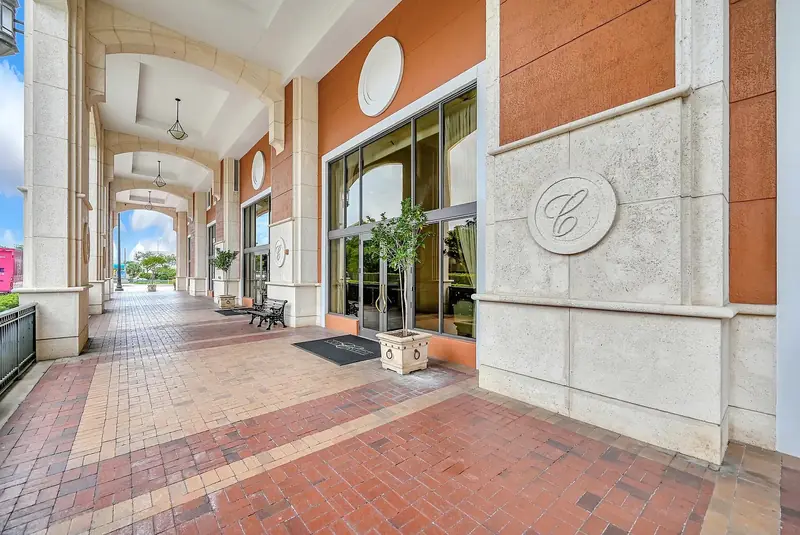 Covered entrance arcade at The Colonnade, with stone columns and the Colonnade monogram.