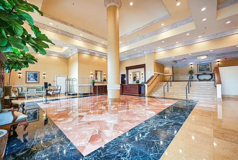 The Colonnade lobby, with a marble floor, reception desk and stairs.